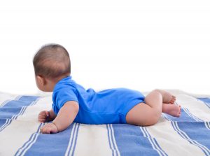 image of baby laying on bed