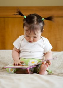 One year old baby and book